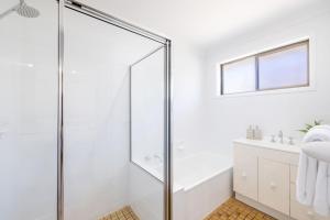 un baño con ducha y lavabo en Hanks Corlette House, 49 Pantowora St - pet friendly, air con, boat parking, Wi-Fi, en Corlette 33 fotos más