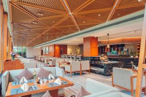 a restaurant with tables and chairs and a bar at Grand Scent Hotel in Chengdu
