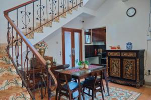 a dining room with a table and a staircase at nDalem Jobali Guesthouse Jogja in Seturan