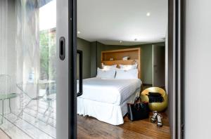 a bedroom with a bed with white sheets and pillows at Le Petit Létraz in Duingt