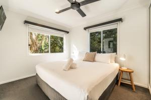 a white bedroom with a large bed and two windows at BIG4 Saltwater Yamba Holiday Park in Yamba +48 photos