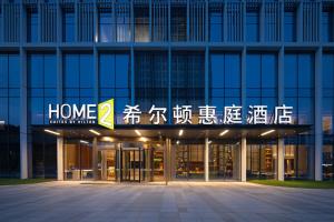 日照日照万平口希尔顿惠庭酒店的一栋建筑，上面写着“家庭正义伙伴”