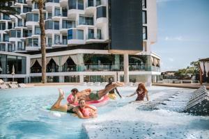 a group of people playing in the pool at a resort at Hard Rock Hotel Ibiza in Playa d'en Bossa