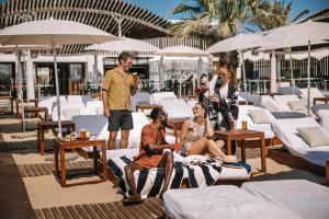 a group of people sitting on the beach at Hard Rock Hotel Ibiza in Playa d'en Bossa