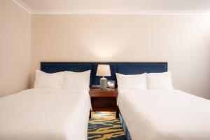 una camera d'albergo con 2 letti e una scrivania con lampada di Holiday Inn Golden Mile by IHG a Hong Kong