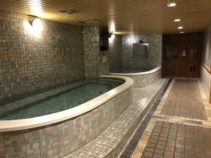 a large jacuzzi tub in a bathroom with a tv at Chuto Plaza Hotel in Taoyuan