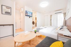 東京にあるNew Cozy APT Located on the Japanese Local shopping streetのベッドとテーブルのあるホテルの部屋