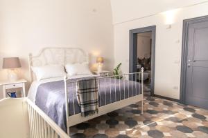 a white bedroom with a bed and a staircase at Marinella Suite Home in Locorotondo