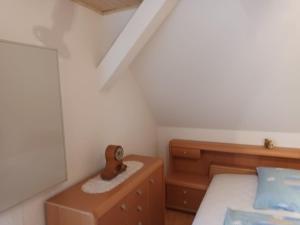 a small bedroom with a bed and a dresser at Ferienwohnung Wiesenblick Dachgeschoß Sonnenberg Grambow in Sonnenberg