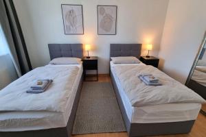 two beds in a small room with two lamps on tables at LIME HOMES Balkon, Küche, Messe, Marienburg in Sarstedt
