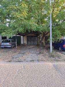 a garage with two cars parked in front of it at Apartman Emilija in Bačka Palanka