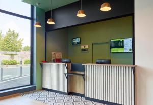 a fast food restaurant with green walls and a counter at B&B HOTEL Paris Clichy-sous-Bois 3 étoiles in Clichy-sous-Bois