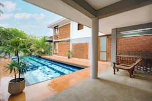 a swimming pool with a bench and a house at KoLac Villa in Elagawagoda +14 photos
