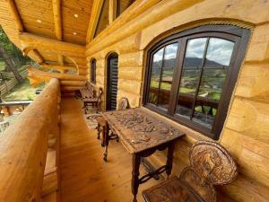 a room with a table and a window in a log cabin at Cabana Ursilor in Vama