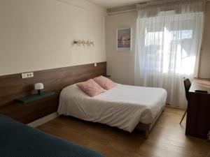 a bedroom with a bed with white sheets and a window at Anne De Bretagne in Vannes