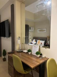 a kitchen with a desk and two yellow chairs at Cozy & Homey Avida Towers Tower 2 in Davao City