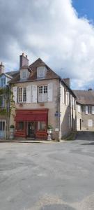 Un gran edificio con puertas rojas en una calle. en Vincent B&B, en Boussac