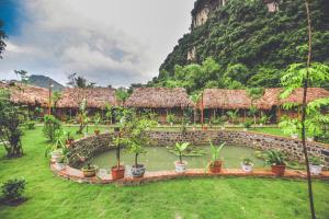 um resort com um jardim com vasos de plantas e uma montanha em Tam Coc Rice Fields Resort em Ninh Binh