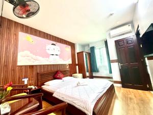 Un dormitorio con una cama y un cuadro en la pared. en Khách Sạn Khánh Vy Airport TSN - Cổng Nhà Ga T3, en Ho Chi Minh