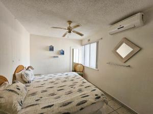 a bedroom with a bed and a ceiling fan at Beachcombers 13 in Ballito +6 photos