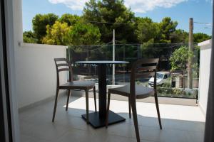 un tavolo e due sedie su un balcone di Montedarena Hotel a Pulsano