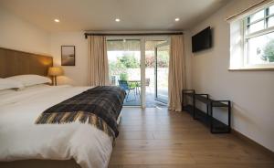 朗德斯通WITHIN THE VILLAGE的带床和滑动玻璃门的卧室