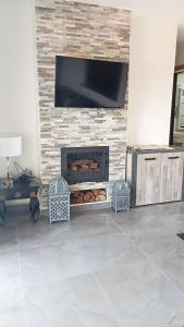 a living room with a fireplace with a flat screen tv at perla Saïdia in Saidia  +3 photos