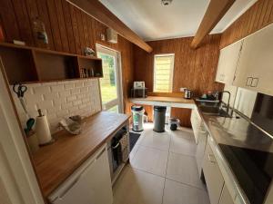 a kitchen with white appliances and wooden walls at Wood Place in Diss