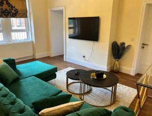 a living room with a couch and a table at 3 Bed - Sleeps 7 - Free Parking - Central Location in Glasgow