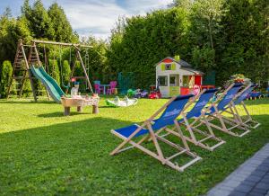 a group of chairs sitting on the grass in a playground at Apartamenty Zatoka Relaksu Sauna i Balia in Polańczyk
