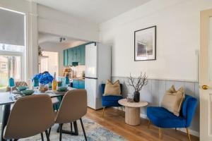 a kitchen and dining room with blue chairs and a table at Modern House By LiveStay Short Lets & Serviced Accommodation Luton With Private Garden, BBQ & Free WiFi in Luton