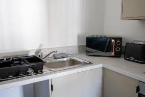 a kitchen counter with a sink and a microwave at Balmoral Stays 5 - Second Floor in Blackpool