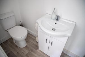 a white bathroom with a toilet and a sink at Balmoral Stays 5 - Second Floor in Blackpool