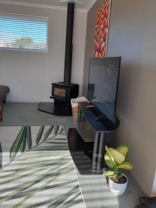 a living room with a television and a fireplace at 3 bedroom holiday home in prime Kaikoura location! in Kaikoura +11 photos