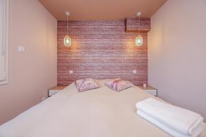 a bedroom with a large white bed with two pillows at Le Cosy - Appartement avec Jardin Wimille proche Wimereux in Wimereux