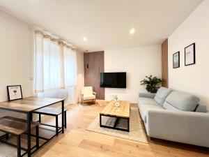 a living room with a couch and a table at La parenthèse Pictave - centre-ville de Poitiers in Biard