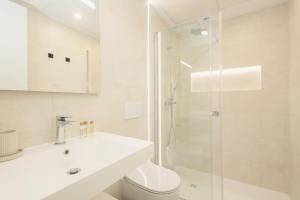 a white bathroom with a toilet and a shower at Brand-new beachside apartment, with spacious terrace and exceptional amenities, in Fuengirola in Fuengirola +47 photos