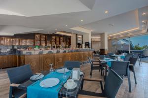 a restaurant with blue tables and chairs and a bar at Green Garden City Luxury Apartments in Alanya