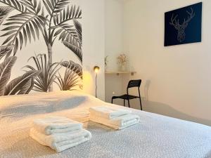 a bedroom with a bed with towels on it at La parenthèse Pictave - centre-ville de Poitiers in Biard