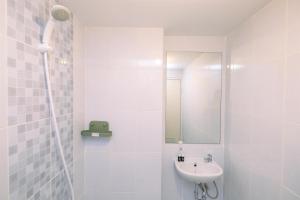 a white bathroom with a sink and a mirror at Comfort and Nice 2BR at Tokyo Riverside PIK 2 Apartment By Travelio in Rawalembang +17 photos