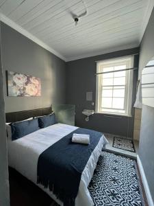 a bedroom with a large bed and a window at CapePod Sea Point in Cape Town