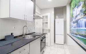 a kitchen with a sink and a refrigerator at Stunning Apartment In Fuengirola in Fuengirola