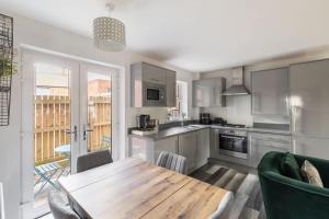 a kitchen with a wooden table and a dining room at Host & Stay - Shipwright Lodge in Whitby