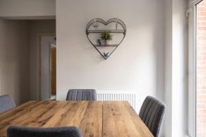 a wooden table with chairs and a heart on the wall at Host & Stay - Shipwright Lodge in Whitby +14 photos