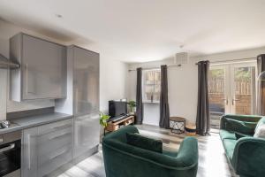 a living room with two green chairs and a tv at Host & Stay - Shipwright Lodge in Whitby