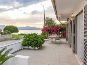 a patio with a table and chairs and flowers at 274 Villa Manresa ETV 4301 by Mallorca Charme in Alcudia