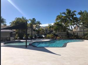 a swimming pool with palm trees in a resort at Elanora 3 bedroom apartment in Gold Coast