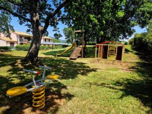 a playground with a tree and a slide at Villaggio Le Querce in Sorano