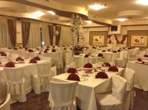 a banquet hall with white tables and white chairs at Hotel Iscla in Edolo