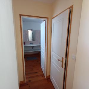 eine offene Tür, die zu einem Badezimmer mit Spiegel führt in der Unterkunft Chambre des bords de Siame in Gratot